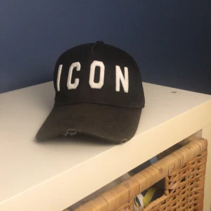 DSQUARED 2 keps - Säljer min DSQUARED 2 keps för endast 450kr, den är lite solblekt men arnas håller den högsta sick!  Man kan anpassa storleken med hjälp av spennet på baksidan. 