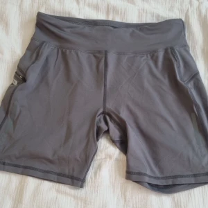 Gråa träningsshorts - Gråa träningsshorts. Strl. M. Snöre på insidan och en ficka på sidan. Köpta från Ullared för något år sedan. Aldrig använda. 