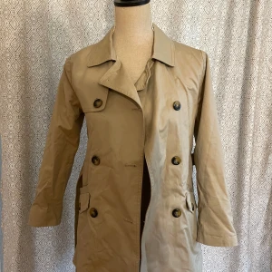 Trench coat barn - Storlek 11/12. 152 cm. Stilig rock för barn, små små fläckar på den men i det stora hela gott skick. Sällan använd.