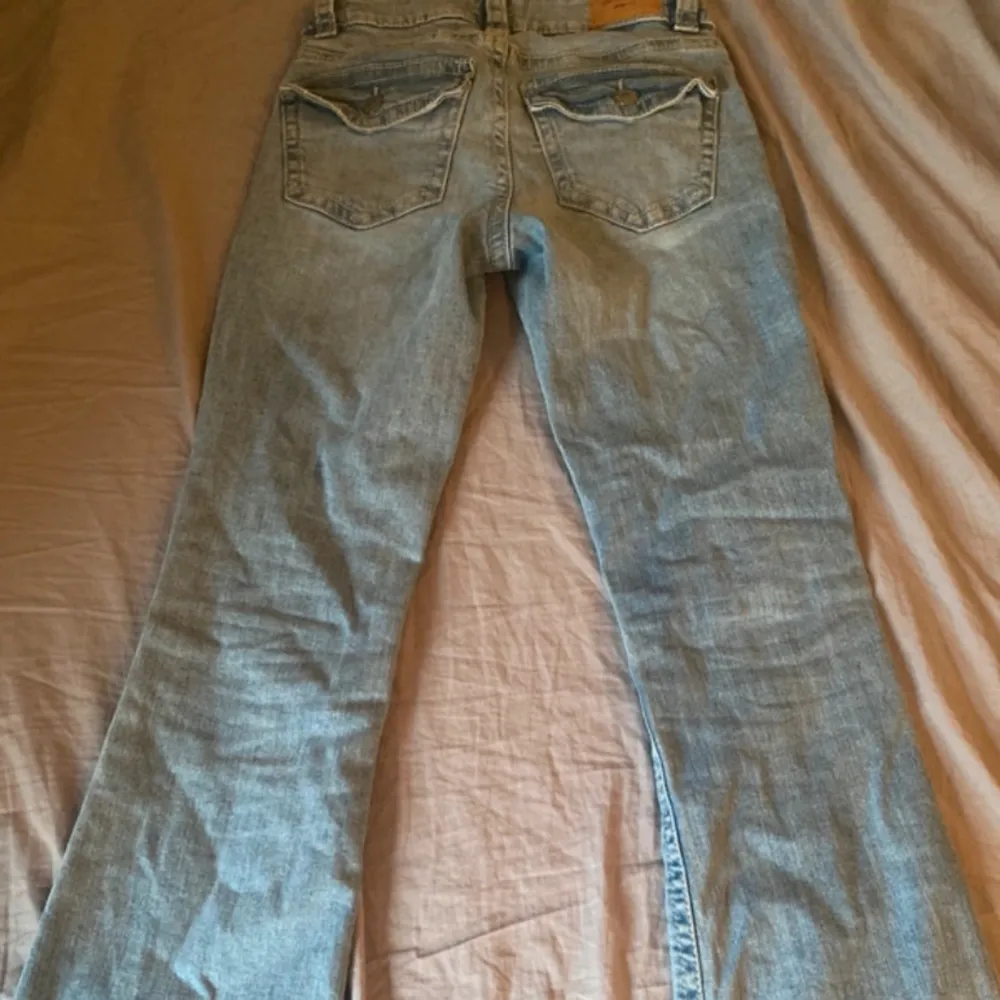 Ett par ljusblå jeansbyxor från Perfect Jeans / gina i storlek 34. Byxorna har en klassisk femficksdesign och är tillverkade i denim. De har en bootcut-stil och är lågmidjade.. Jeans & Byxor.