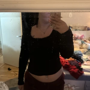 Svart långärmad topp från Romwe - Säljer en svart långärmad topp från Romwe i storlek L. Toppen har ribbat material, spetsdetaljer längs urringningen och en liten rosett framtill. Perfekt för dig som gillar enkla men snygga basplagg.