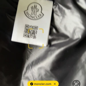 Svart dunväst från Moncler - Säljer en svart dunväst från Moncler med klassisk logotyp på bröstet. Västen har dragkedja framtill och stora vadderade paneler som ger en puffig look. Perfekt för lager-på-lager-stil under kyliga dagar.