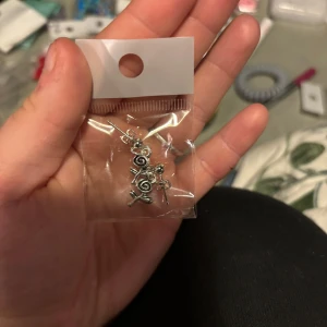 Söta örhängen med klubbor i silverfärg - Säljer ett par örhängen formade som små klubbor i silverfärg. Perfekta för dig som vill ha något lekfullt och unikt i öronen. Kommer i en liten plastpåse.