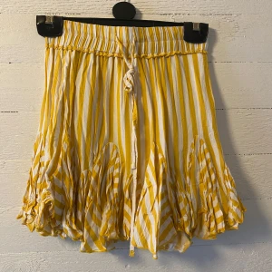 Gul och vit randig kjol från Vrggrl - Superfin kortkjol från Vrggrl i gul och vit randigt mönster. Kjolen har volangdetaljer och knytband i midjan. Aldrig använd! 🤗