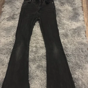 Svarta flare jeans från 157 - Säljer ett par svarta flare jeans från 157 i storlek XS short. Byxorna har klassisk femficksdesign, låg midja och utsvängda ben. Perfekta för dig som gillar en retroinspirerad look med mycket attityd.