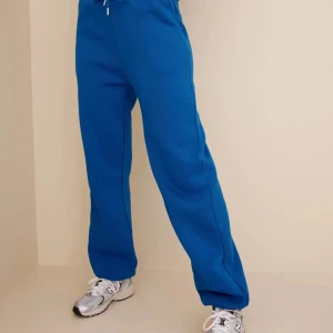 Blå mjukisbyxor med snörning - Säljer ett par bekväma blå mjukisbyxor med elastisk midja och snörning. Byxorna har ribbade muddar vid bensluten för en skön passform. Perfekta för en avslappnad stil.