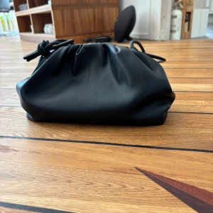 Svart handväska med knyt - Intrrssekoll på en svart handväska från Carin Wester. Väskan har en mjuk, puffig form och är perfekt för att bära det viktigaste. Enkel och stilren design som passar till många outfits. Man kan även ta bort bandet för att få en clutch. Nypris 499kr.  Skriv vid intresse💕