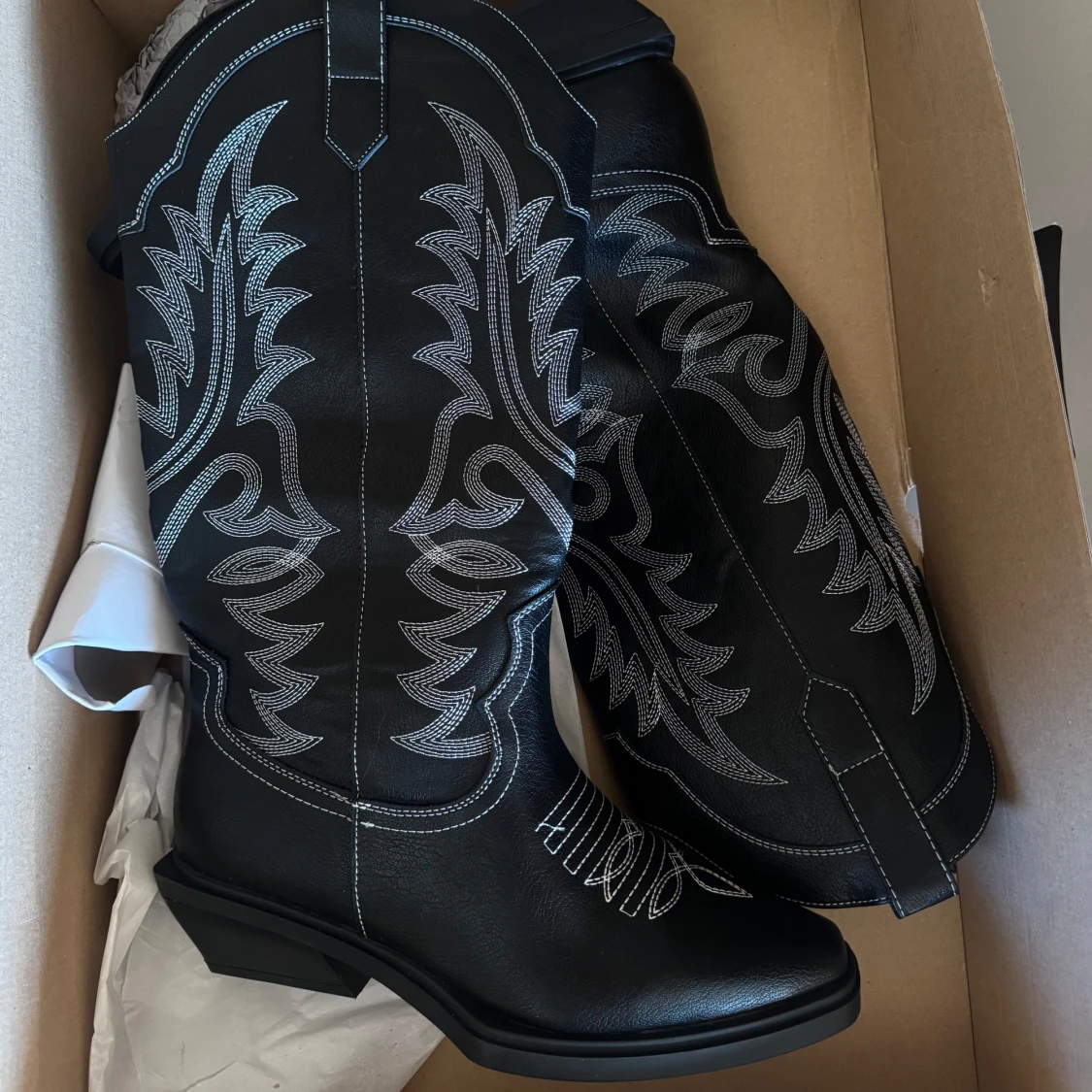 Svarta cowboy boots med vit brodyr