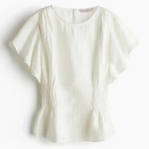 Vit blus med korta ärmar - Säljer en slutsåld vit blus från h&m. Blusen har en lätt rynkad midja som ger en fin passform och är tillverkad i ett mjukt, strukturerat tyg. Går att förhandla om pris 