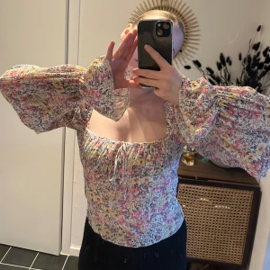 Blommig topp - Superfin blommig långärmad tröja topp med jättefin urringning. Utsvängda ärmar, stretchig, super skön!   Använd 2 ggr. Från gina i strl xs. Skulle säga att den är normal i storleken  Har bundle rabatt, kolla gärna mina andra annonser. Allt ska bort🫶🏼 