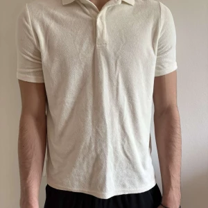 Vit piké t-shirt handduksmaterial  - Säljer en stilren vit piké t-shirt handduksmaterial med krage och korta ärmar. Pikén har en klassisk passform och är tillverkad i ett mjukt material som känns skönt mot huden. Perfekt för en avslappnad och snygg look.