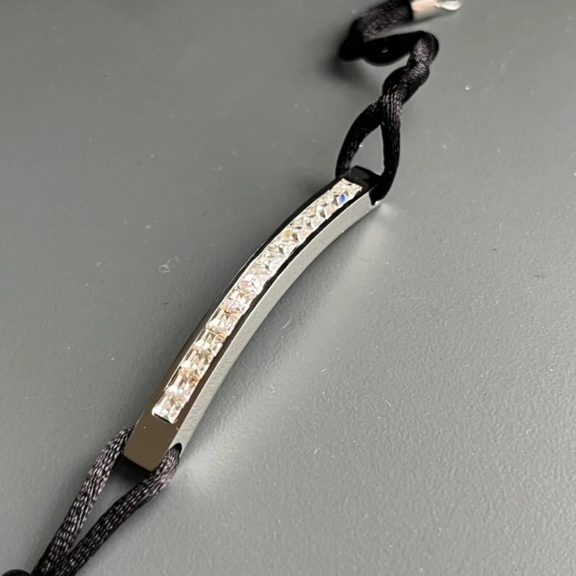 Svart armband med silverfärgad detalj och glittriga stenar - 1