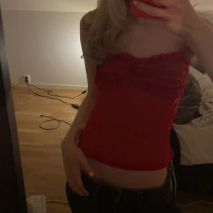 Röd croppad tubtopp med volang - Säljer en röd croppad tubtopp med volangdetaljer upptill. 