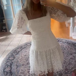 Vit studentklänning i spets med puffärm - Superfin vit klänning från ML MONIQUE LHUILLIER med spets och puffiga kortärmar. Perfekt för studenten! Endast använd en gång. Helt slutsåld nypris 6100kr