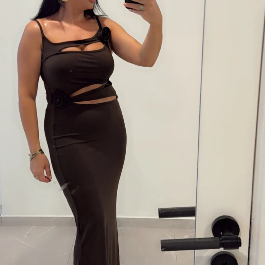 Svart långklänning med cut-outs och rosettdetaljer