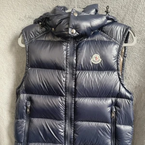 Moncler vest  - Säljer en äkta moncler vest. Mycket bra skick. Vesten är mörkblå och i storlek 2 vilket motsvarar M. Finns fler bilder så hör av er vid intresse! Pris går att sänkas vid snabb affär. Kvitto och tags finns kvar!