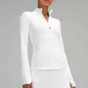 Lululemon define jacket - Säljer en vit, figursydd träningsjacka från Lululemon med dragkedja framtill och höga fickor med dragkedja. Jackan har lång ärm och stårkrage, tillverkad i ett stretchigt material som andas. storlek 2