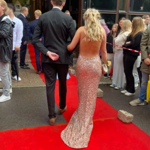 Champagnefärgad glittrig balklänning  - Säljer nu min balklänning som är använd 1gång. Klänningar är i mycket bra skick och är uppsydd så längd går justera. Köpt på Dressroom i Göteborg och har storlek 34. Vid fler bilder och funderingar hör av dig❤️