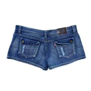 Blå jeansshorts - Blå mini jeansshorts med låg midja och slitna detaljer. Shortsen har en cool tvättad look och är så snygga! 