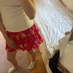 Röd blommiga shorts från Odd Molly - Supersöa röda shorts från Odd Molly med blommigt mönster och volangkant. Shortsen har en luftig och flowy passform, perfekt för varma dagar. Materialet är mjukt och känns skönt mot huden. Jag är 170 lång o storlek s tror dom oxå är s då dom passar bra men kommer inte till användning tyvärr🤍🤍