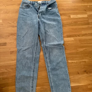 Ljusblå jeans från H&M, strl 36 - Säljer ett par ljusblå jeans från H&M i storlek 36. Modellen har klassisk femficksdesign, raka ben och hög midja. Jeansen är tillverkade i 100% bomull och har knapp- och dragkedjestängning framtill. Perfekta för en chill och stilren look.