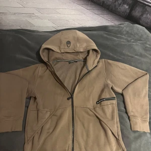Sail racing hoodie brun - storlek 170 - Snygg brun hoodie från Sail Racing. Sitter som Xs, passar för dig som är 165-175. Inga synliga defekter. Säljer endast för att jag inte använder den längre. Helt fri från nopprighet och känns som ny i materialet. Skriv gärna om ni har frågor🤗. Nypris 899.