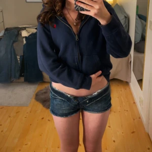 Blå jeansshorts från H&M, strl 36 - Säljer ett par blå jeansshorts från H&M i storlek 36. De har låg midja och råa, fransiga kanter nedtill. Materialet är slitstarkt denim och färgen är snyggt tvättad med ljusare partier. Perfekta för varma dagar och chill stil. Ja använder ofta 32-36 och är jätte sköna och stretchiga! Pris kan diskuteras!💸