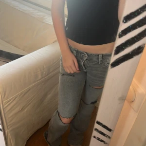 Grå ripped jeans med bootcut - Säljer ett par grå jeans med slitna hår vid knäna och låren, aldrig använda och köpta för en ca ett halv år sedan. Lågmidjade bootcut som passar till många olika outfits. 