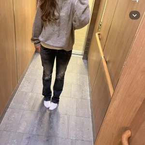 Svarta bootcut jeans med slitningar - Snygga svarta jeans med coola slitningar och lätt tvättade detaljer på låren och knäna. Modellen har bootcut-ben som ger en schysst siluett och passar perfekt till sneakers eller boots. Klassisk femficksdesign och låg midja för en avslappnad vibe. Storlek är 28/34. Ett litet hål vid sidan men som inte syns. Skriv för fler bilder❤️köp ej direkt 