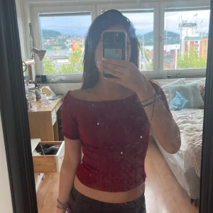 Vinröd offshoulder topp från H&M - Snygg vinröd offshoulder topp från H&M i mjuk bomull. Modellen har korta ärmar och en figurnära passform som sitter perfekt över axlarna. Perfekt för dig som vill ha en enkel men trendig look med lite edge. Använd 3 gånger typ