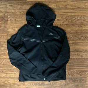 Svart Nike tech storlek M - En svart nike tech med inga bekymmer förutom att den börjar knoppra. Storlek M