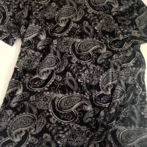 Svart t-shirt med paisleymönster - Svart t-shirt med detaljerat paisleymönster i grått och vitt. Kortärmad och tillverkad i mjukt bomullstyg som känns skönt mot huden. Perfekt för dig som gillar unika prints och vill sticka ut med en cool stil.