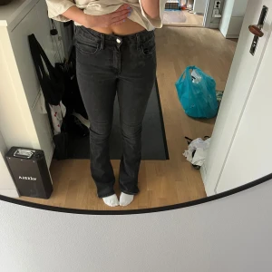 Svarta bootcut jeans - Säljer ett par svarta jeans med bootcut passform. Jeansen har klassisk femficksdesign, hög midja och är gjorda i mjukt denim-material. De har använd väl och är därför slitna nere vid benen.