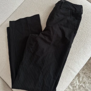 Svarta kostymbyxor med smala ränder - Snygga svarta kostymbyxor från Madlady med smala vita ränder i storlek 32/ short. Klassisk rak passform och passar mig som är 160. Aldrig använda 
