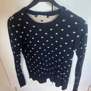 Mörkblå prickig stickad tröja Boomerang - Säljer en mörkblå stickad tröja från Boomerang i storlek S. Tröjan har ett gulligt vitt prickigt mönster över hela.