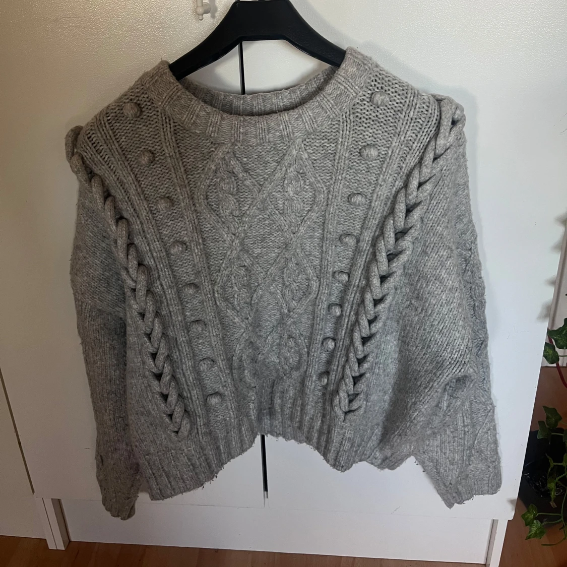 Grå stickad tröja med flätmönster