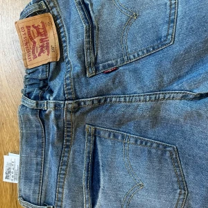 Levi's 510 ljusblå jeans - Säljer ett par Levi's 510 jeans i ljusblå tvätt med klassiska fem fickor och snygga kontrastsömmar. Modellen är slim och har en rak passform med normal midja. Ikonisk Levi's-lapp baktill och röd etikett på fickan. Perfekt för dig som gillar en clean och tidlös look.