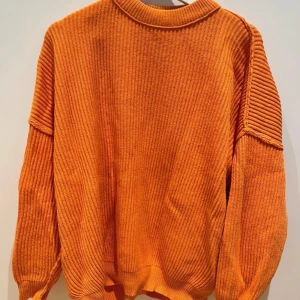 Orange stickad tröja från ASOS DESIGN - Säljer en orange stickad tröja från ASOS DESIGN i storlek EU 36. Tröjan har ribbad struktur, rund hals och långa ärmar med snygga detaljer vid axlarna. Perfekt för dig som gillar färg och vill ha en mysig och trendig look.