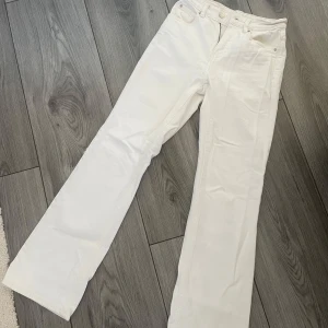 Vita jeans  - Snygga vita jeans från Ginatricot i rak/bootcut modell med klassiska fem fickor och bälteshällor. Byxorna har dragkedja och knapp framtill, samt en stilren look som passar till många olika outfits. Perfekt längd för 160 