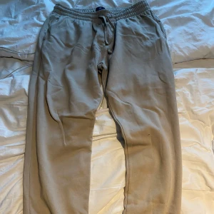 Beige mjukisbyxor  - Säljer ett par beige mjukisbyxor från H&M i storlek L. Byxorna har regular fit, elastisk midja med snörning och är gjorda i en mjuk bomulls- och polyestermix. Perfekta för chill dagar eller när du vill vara extra bekväm.