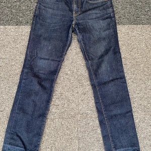 Levi's 511 mörkblå jeans W29 L32 - Snygga Levi's 511 jeans i mörkblå tvätt med klassiska kontrastsömmar och fem fickor. Modellen är slim och har en rak, smal passform som sitter grymt på benen. Jeansen är tillverkade i slitstarkt bomullsdenim och har dragkedja i gylfen.