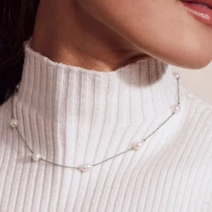Silverhalsband med pärlor från Edblad  - Ett stilrent halsband i silverfärgad kedja med små vita pärlor utspridda längs hela kedjan. Perfekt för dig som gillar minimalistiska smycken med en elegant touch. Passar till allt och ger en fräsch känsla till din look.