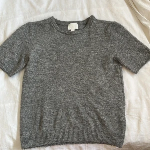 Grå stickad t-shirt  - Mörkgrå stickad t-shirt från H&M i storlek XS. Använd men i mycket bra skick. 