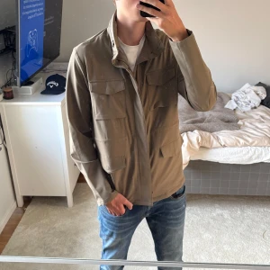Grön field jacket - Säljer nu denna kaki färgade field jackan som köptes tidigare i våras. Nypriset ligger på 3400 och den har inga defekter! Hör gärna av vid fler funderingar!