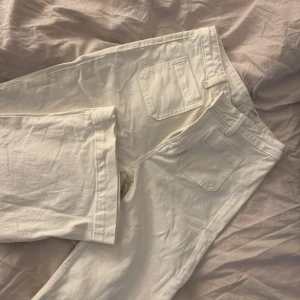 Vita wide jeans från Never Denim - Säljer ett par nya vita jeans från BikBok i modellen Camille. De har breda ben, hög midja och raka fickor både fram och bak.  
