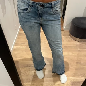 Ljusblå lågmidjade jeans - Ett par ljusblå lågmidjade jeans från Next. Dessa är jätte snygga men tyvärr lite korta på mig. De har använts flitigt och är lite slitna men fortfarande snygga. Innerbenslängs: 77 cm Ytterben: 100cm midja rakt över: 40 cm. Finns två knappar så man kan reglare midjan. 