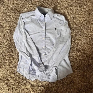 Ljusblå skjorta från Ralph Lauren🤩🙌 - Klassisk ljusblå skjorta från Ralph Lauren med broderad logga på bröstet. Skjortan passar in i storleken Xs🤩🙌