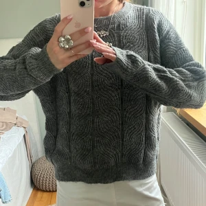 Mörkgrå stickad tröja med kabelmönster - Säljer en mysig mörkgrå stickad tröja med snyggt kabelmönster. Tröjan har rund hals och långa ärmar!🫶🏻