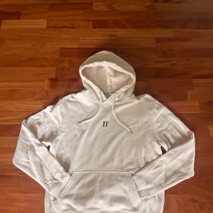 Beige hoodie från Les Deux med huva - Tja!                                                                                     Jag säljer en stilren beige hoodie från Les Deux i storlek S. Tröjan är i mjuk bomullskvalitet och har ribbade muddar vid ärmslut och nederkant som ger en perfekt passform. Endast använd ett fåtal gånger.