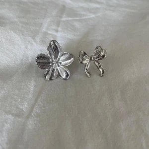 Ringar - Säljer två silver ringar från Shein som föreställer en blomma och en rosett. Båda är bara använd en gång och är då i mycket bra skick💗 